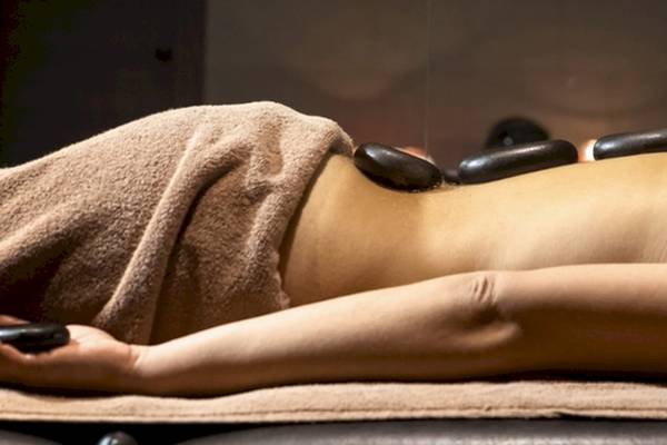 Eine Person im Lagomandra Beach Hotel genießt eine Massage mit heißen Steinen.