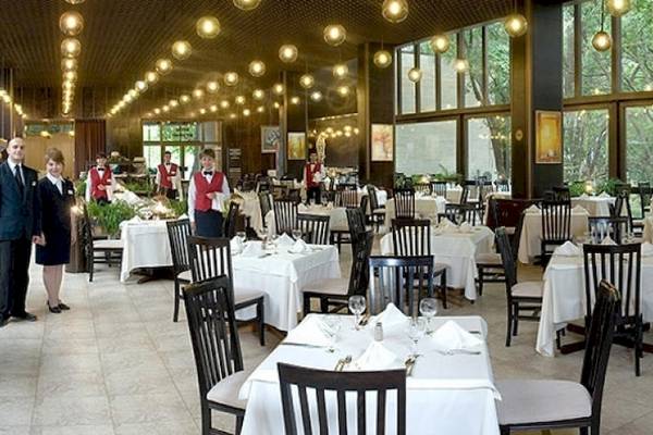 Innenbereich des Riviera Beach Hotel Restaurants mit gedeckten Tischen und wartendem Personal.