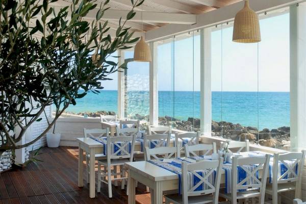 Terrasse des Riviera Beach Hotels mit Blick auf das Meer und Felsen.