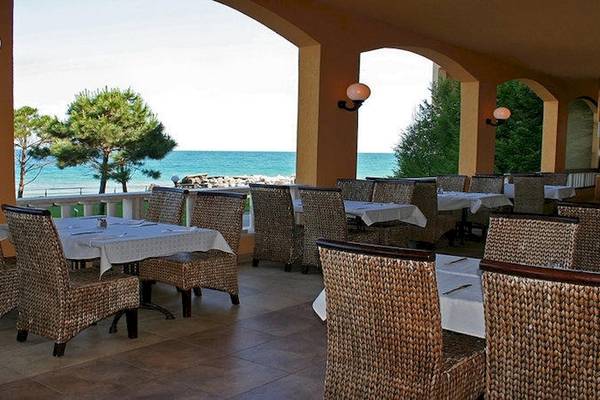 Terrasse des Riviera Beach Hotels mit Blick auf das Meer und Bäume
