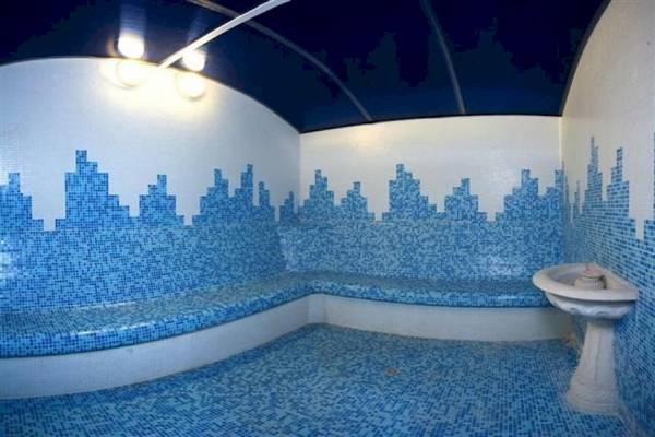 Sauna-Raum im Riviera Beach Hotel mit blauen Fliesen und Sitzbank.