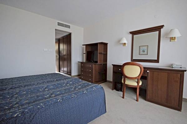 Ein elegantes Hotelzimmer mit einem Bett, Schreibtisch, Stuhl und Spiegel.