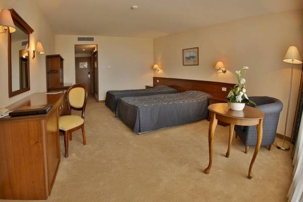 Doppelzimmer im Riviera Beach Hotel mit zwei Betten, Schreibtisch, Spiegel und Beleuchtung.