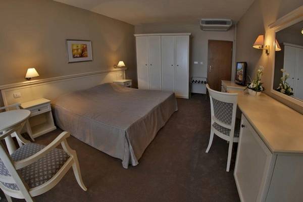 Ein luxuriöses Zimmer im Riviera Beach Hotel mit einem Bett, Möbeln und Dekoration.