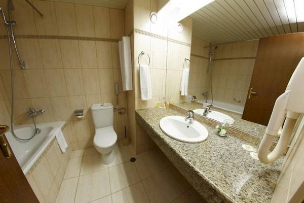 Badezimmer im Riviera Beach Hotel mit Badewanne, Toilette und Waschbecken.
