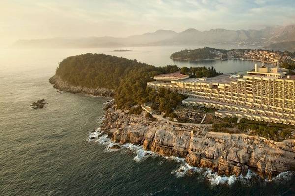 Luftaufnahme des Croatia Hotels auf einer Klippe am Meer mit Bergen im Hintergrund.