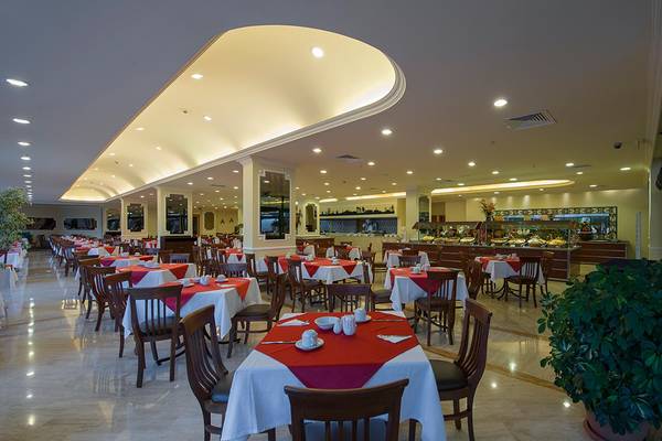 Innenansicht des Miramare Queen Hotel Restaurants mit vielen gedeckten Tischen und Stühlen.