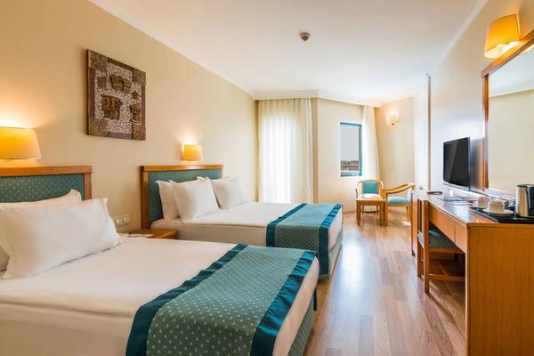 Doppelzimmer im Miramare Queen Hotel mit zwei Betten, Fernseher und Schreibtisch.