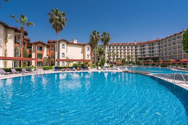 Außenbereich des Miramare Queen Hotels mit Swimmingpool und Sonnenliegen.