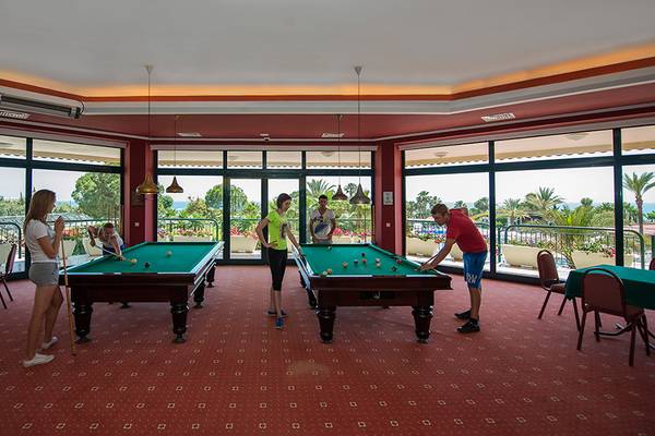 Gruppe von Gästen spielt Billard im Poolbereich des Miramare Queen Hotels.