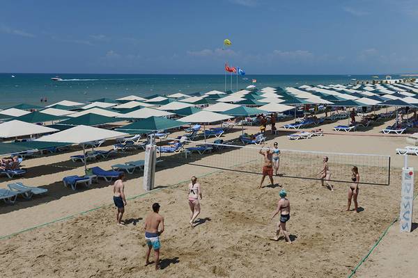Volleyballspiel am Strand des Miramare Queen Hotels mit vielen Sonnenschirmen und Liegestühlen.