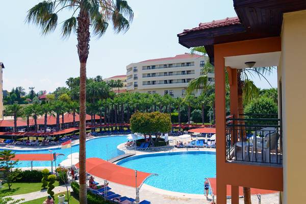 Außenbereich des Miramare Queen Hotels mit Swimmingpool, Liegestühlen und Gebäuden