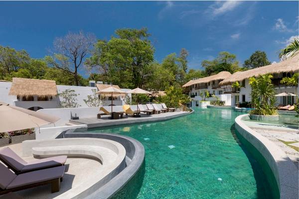Außenpool des Eden Beach Khao Lak Resort & Spa mit Sonnenliegen und Sonnenschirmen.