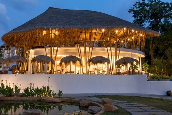 Eden Beach Khao Lak Resort & Spa bei Nacht mit beleuchteter Dachterrasse und Bambusschirmen