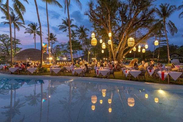 Pool-Restaurant des Eden Beach Khao Lak Resort & Spa bei Nacht mit Gästen und hängenden Lampen.