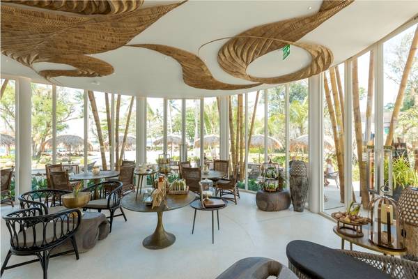 Innenbereich des Restaurants im Eden Beach Khao Lak Resort mit modernen Möbeln und großen Fenstern.