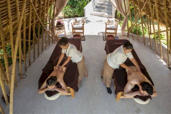 Massage Behandlung im Eden Beach Khao Lak Resort & Spa mit zwei Personen, die Rückenmassagen durchführen.