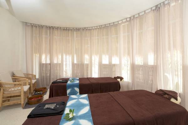 Massagebereich im Eden Beach Khao Lak Resort & Spa mit zwei Massagebetten und weißen Vorhängen.
