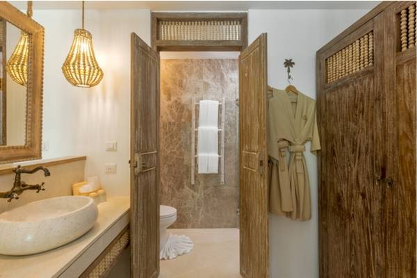 Badezimmer im Eden Beach Khao Lak Resort & Spa mit offenem Bad, Toilette, Waschbecken und Holztüren.