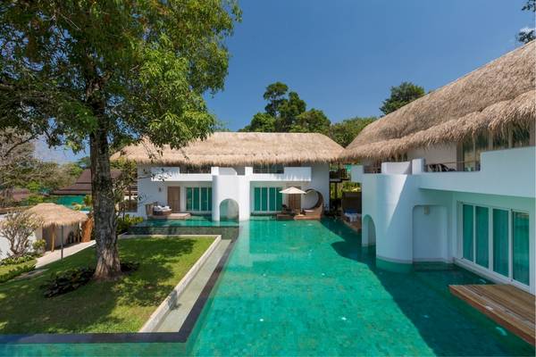 Außenbereich des Eden Beach Khao Lak Resort & Spa mit Swimmingpool und Sonnenliegen.