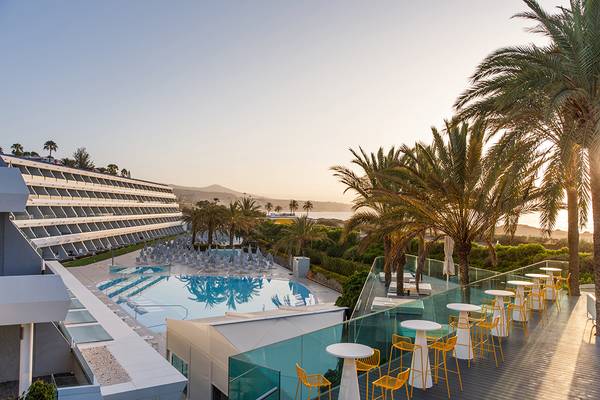 Außenbereich des Santa Monica Suites Hotels mit Swimmingpool und Palmen.