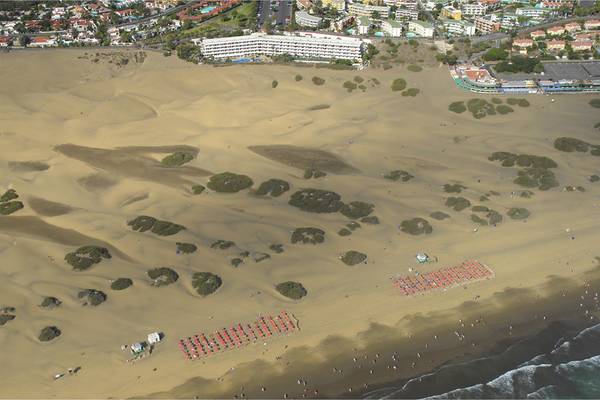 Luftaufnahme der Dünen und des Strandes des Santa Monica Suites Hotels.