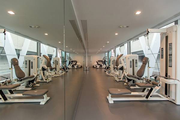 Fitnessstudio im Santa Monica Suites Hotel mit verschiedenen Trainingsgeräten.