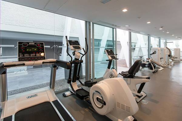 Fitnesscenter im Santa Monica Suites Hotel mit Geräten wie Laufband und Fahrrad
