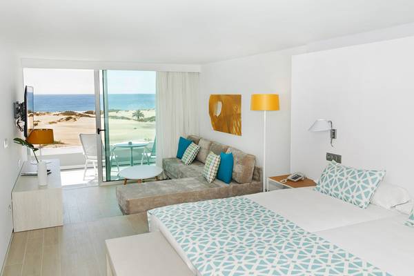 Zimmer im Santa Monica Suites Hotel mit Blick auf das Meer und einen Balkon.