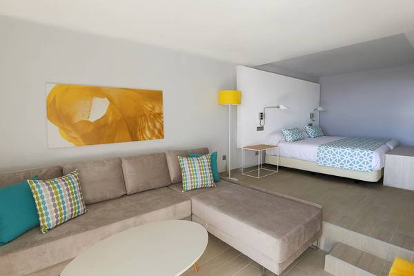 Modernes Zimmerdesign im Santa Monica Suites Hotel mit Bett, Sofa und Tisch.
