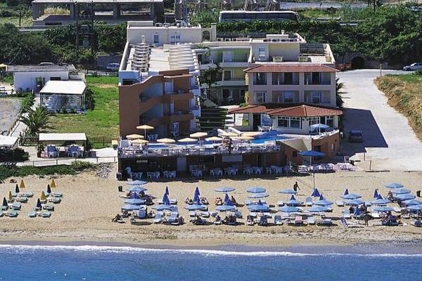 Luftaufnahme des Dedalos Beach Hotels mit Pool und vielen Sonnenschirmen am Strand