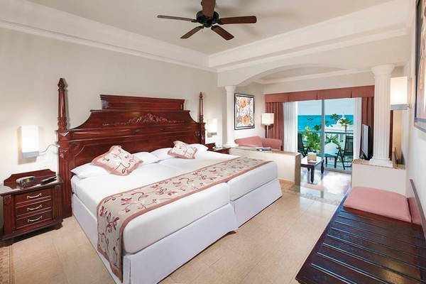 Suite-Zimmer im Riu Palace Las Americas Hotel mit Doppelbett, Klimaanlage und Meerblick.