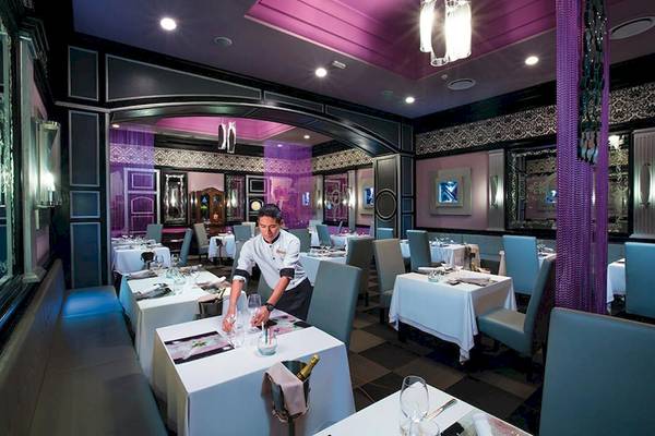 Ein Kellner bereitet Tische in einem eleganten Restaurant im Riu Palace Las Americas vor.