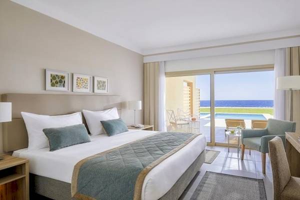 Hotelzimmer im Jaz Maraya Resort mit Meerblick, Bett, Schreibtisch und Fernseher.