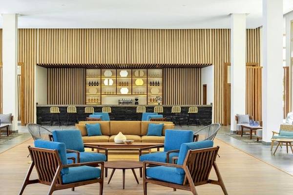 Lobby des Jaz Maraya Resorts mit blauen Stühlen und einem braunen Sofa.