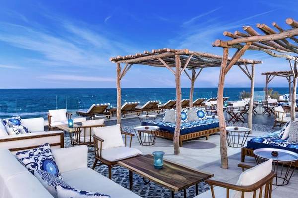 Außenbereich des Jaz Maraya Resorts mit Blick auf das Meer, Loungemöbel und Holzpavillons.