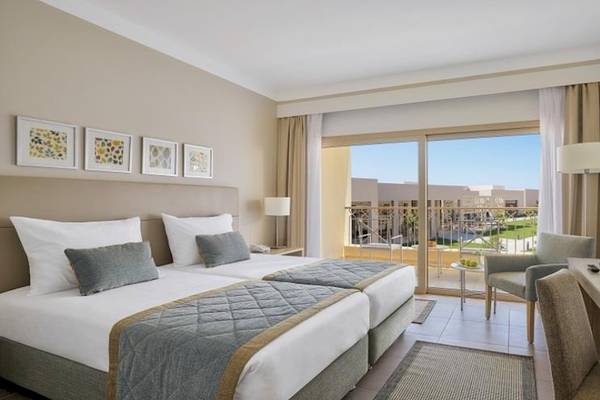Doppelzimmer im Jaz Maraya Resort mit zwei Betten, Schreibtisch, Fernseher und Terrassenblick.