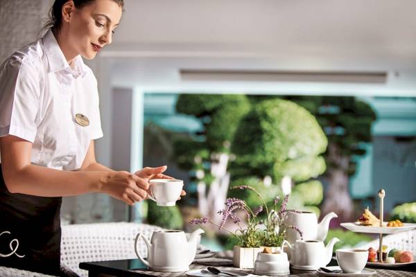 Frau beim Kaffee servieren im Mitsis Alila Resort & Spa