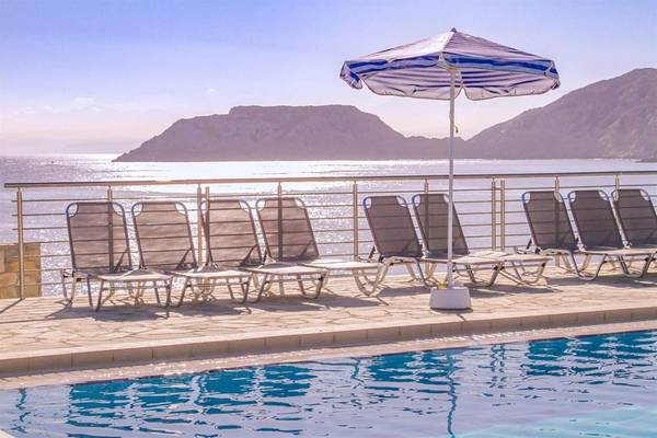 Ein Strandbereich mit mehreren Sonnenliegen und einem Sonnenschirm im Peninsula Resort & Spa.