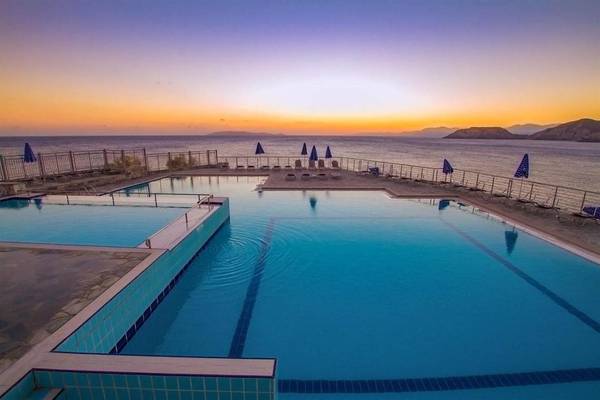Pool im Sonnenuntergang im Peninsula Resort & Spa mit Blick auf das Meer
