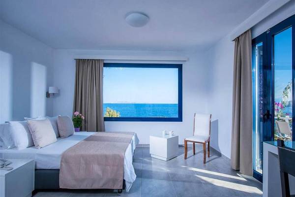 Schlafzimmer mit Meerblick im Peninsula Resort & Spa, mit Bett, Fenster und Aussicht auf das Meer.