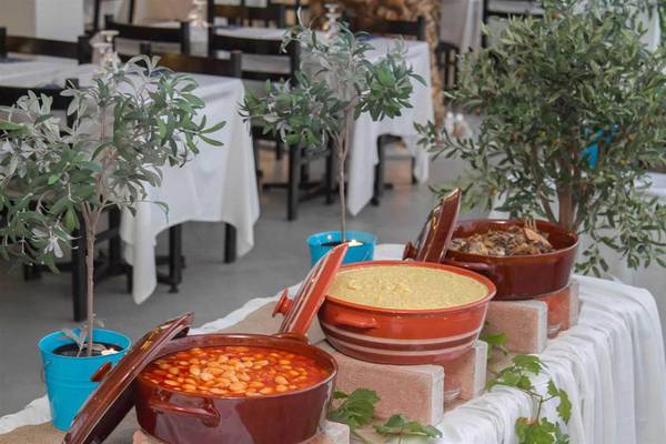 Speisetisch im Peninsula Resort & Spa mit Olivenbäumen und verschiedenen Gerichten