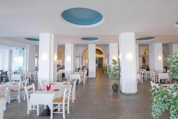 Innenbereich des Peninsula Resort & Spa mit geräumigem Essbereich, weißen Stühlen und Tischen, blauen Decken und einem grünen Topf.