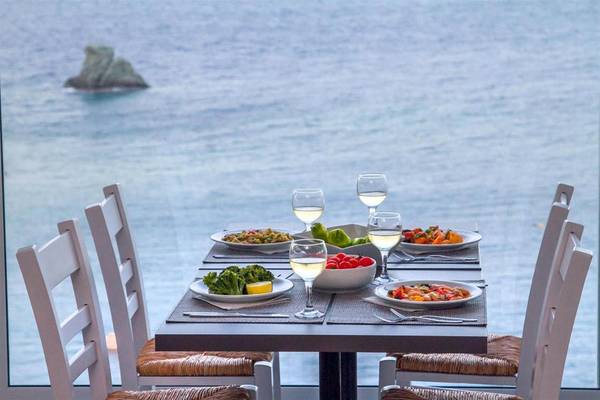 Tisch im Peninsula Resort & Spa mit Blick auf das Meer und Gerichte darauf