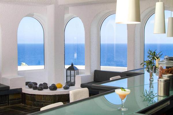 Innenansicht der Hotelbar des Peninsula Resort & Spa mit Blick auf das Meer.