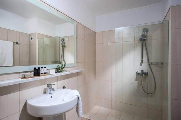 Badezimmer im Peninsula Resort & Spa mit Spiegel, Dusche und Waschbecken.