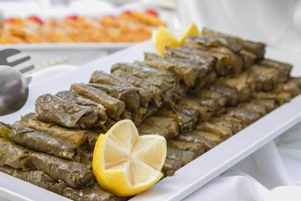 Ein Tisch mit vielen Dolma-Rollen, begleitet von einem halben Zitronenstück, im Peninsula Resort & Spa.