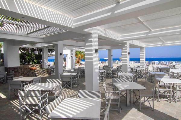 Strandrestaurant im Peninsula Resort & Spa mit weißen Tischen und Stühlen unter schattenspendenden Überdachungen.