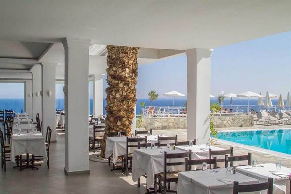 Innenansicht des Restaurants des Peninsula Resort & Spa mit Blick auf den Pool und den Ozean.