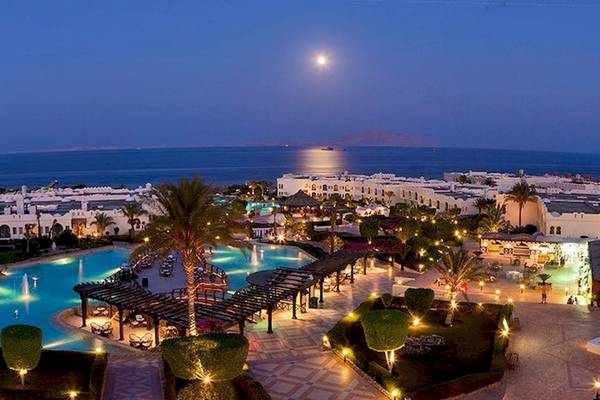 Luftaufnahme des Charmillion Club Resorts mit Swimmingpool und Blick auf das Meer bei Nacht